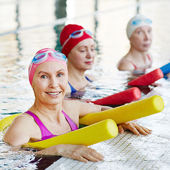 Frauen im Wasser mit Schwimmnudeln